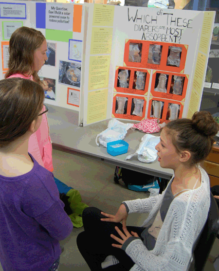 Annabelle Thomas talks to a couple o f friends about her experiment that tested the absorbability of different disposable diapers. David F. Rooney photo