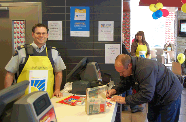 RCMP Staff Sgt. Kurt Grabinsky donned a distinctive yellow apron to take orders from customers. Revelstoke's McDonald's was trying to raise $5,000 for the Ronald McDonald House in Vancouver. On McHappy Day, $1 from every Big Mac sandwich, Happy Meal and hot McCafé beverage was dedicated to that goal. David F. Rooney photo