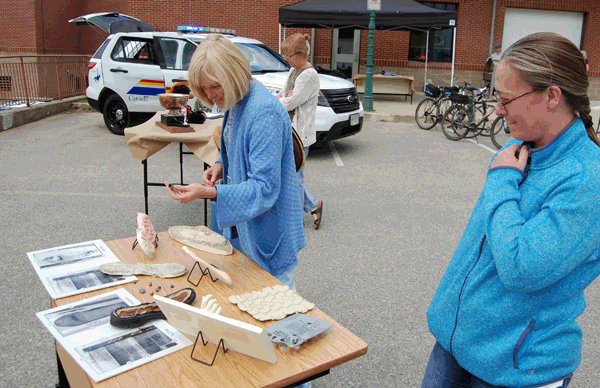 Councillor Connie Brothers (left) and YourLink's Shawn Fillipchuk check out the plaster casts, depended bullets and other forensic items on display at the detachment's Police Week BBQ. David F. Rooney photo