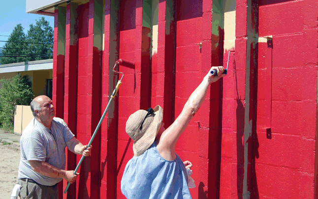 Chuck Ferguson and Margaret Pacaud put some oomph into the new coat of red paint that is enlivening the exterior of the building. David F. Rooney photo