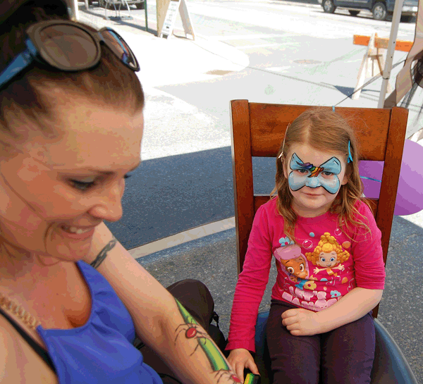 Face Painter Tina Schultz smailes as she prepares to put the finishing touches to the unicorn design on young Tayah Leclerc's face. David F. Rooney photo