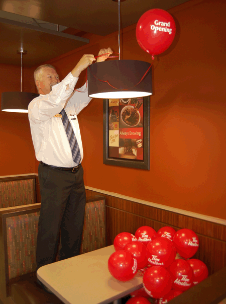 Brian Lecompte, co-owner of Revelstoke's Tim Hortons franchise decorates his restaurant with bright red balloons for the its grand reopening on Saturday, May 9. David F. Rooney photo