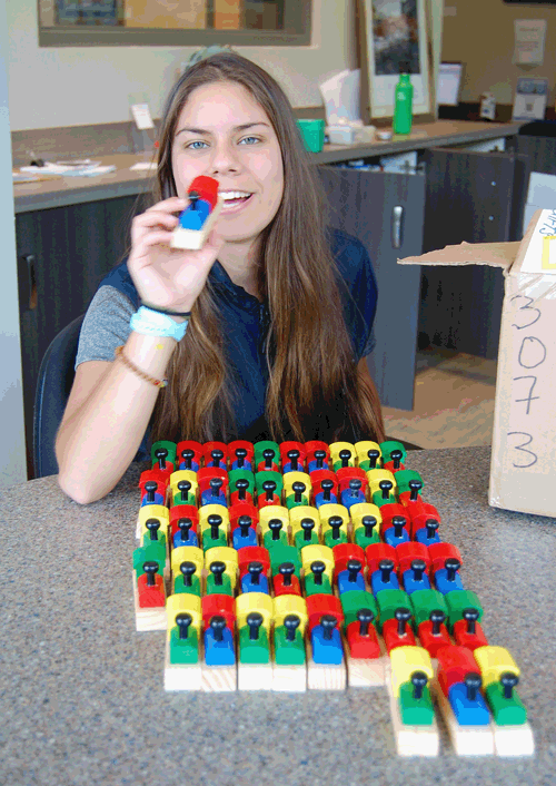 Taryn Walker had something to play with at the Chamber of Commerce on Monday — these colourful wooden whistles shaped like old-time locomotives. David F. Rooney photo