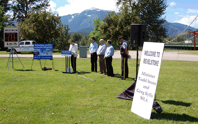 Highway Minister Todd Stone (second from the left) confirmed Monday that there will be relatively immediate improvements to the Trans-Canada Highway coming up, and not only that but eventual improvements to its intersection with Victoria Road. Here, Stone listens as he is introduced to a crowd at Woodenhead Park on Monday, June 15, by Shuswap MLA Greg Kyllo. The other people with Stone are Revelstoke Mayor Mark McKee, Golden Mayor Ron Oszust and Chief Officer Neil Dubord, chair of the BC Association of Chiefs of Police Traffic Safety Committee. The Welcome to Revelstoke sign was erected by local BC Liberals peter Bernacki and Barry Ozero. The digital sign is an example of the signs that will mark the Variable Speed Zone being instated west of Revelstoke. David F. Rooney photo