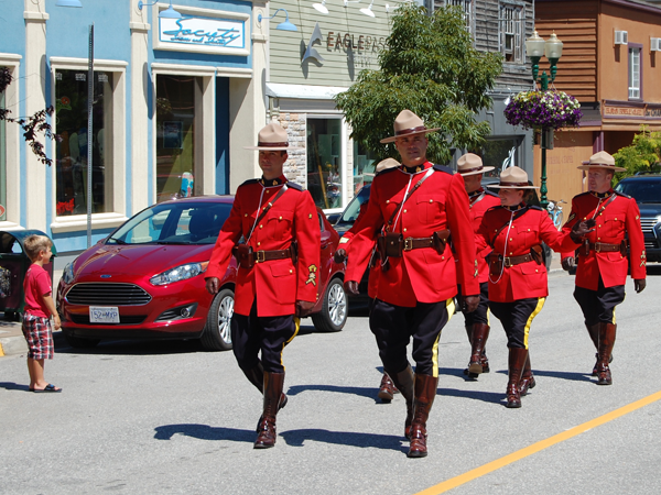 Members of Revelstoke's RCMP detachment demonstrate their fortitude by marching in the 30° heat wearing red serge. David F. Rooney photo