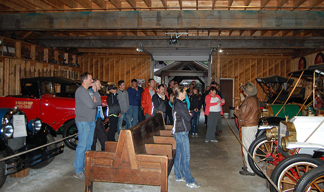 The riders, all serving or retired RCMP and municipal police officers, listen as tour guide Thane Smith regales them with the story of how Gordon Bell built the sprawling hotel and tourist attraction. David F. Rooney photo