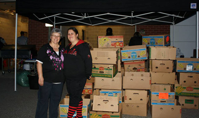 Patti and Krista wait for the food drive volunteers to return with donations to fill all those boxes. Photo courtesy of Community Connections