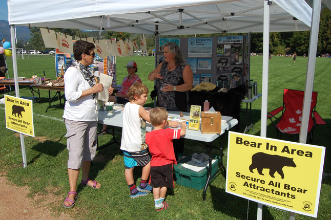Bear Aware Coordinator Sue Davies chats with a mum and her two kids at the Bear Aware booth at Centennial park. David F. Rooney photo