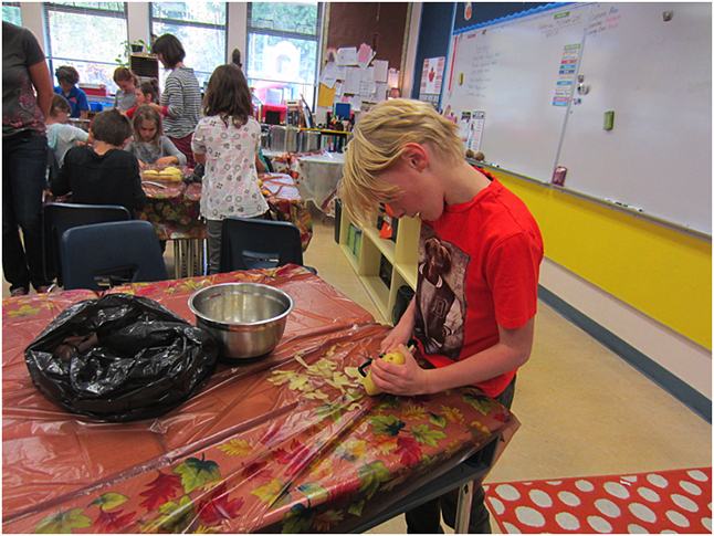 Corbin Martin concentrates on peeling potatoes for the Harvest Lunch last Friday at Arrow Heights Elementary School. Photo by Mrs. Kristi Mortell-Leblanc