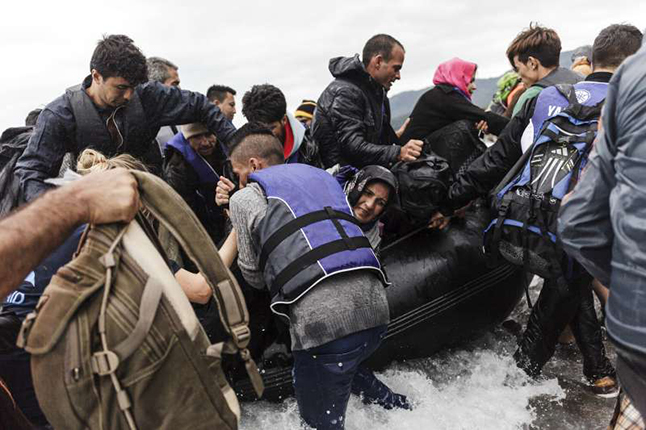 As the war in Syria continues and refugees take long and dangerous journeys to safety, community groups in many countries around the world, including Canada, have organised to to help refugees or sponsor refugee families. Their plight is desperate as you can see in this United Nations High Commission on Refugees of a group disembarking from an inflatable boat after reaching the Greek island of Lesvos. Achilleas Zavallis photo courtesy of the UNHCR