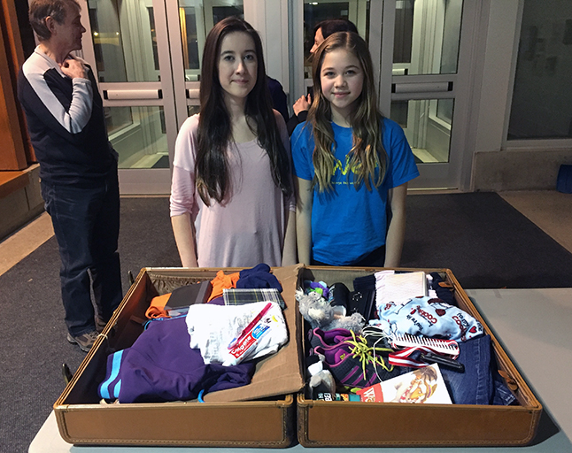 Beth Brodie and Kira Sawatzky, both Begbie View Elementary School Me to We Club members, put together this interesting suitcase full of items you might — maybe not — want if you had to flee from home. David F. Rooney photo