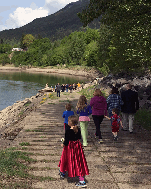 After the short service, participants carried flowers down to the edge of the decommissioned boat ramp, which is where Les fell into the water and was swept away. People laid flowers in the water and watched as they were swept away. David F. Rooney photo