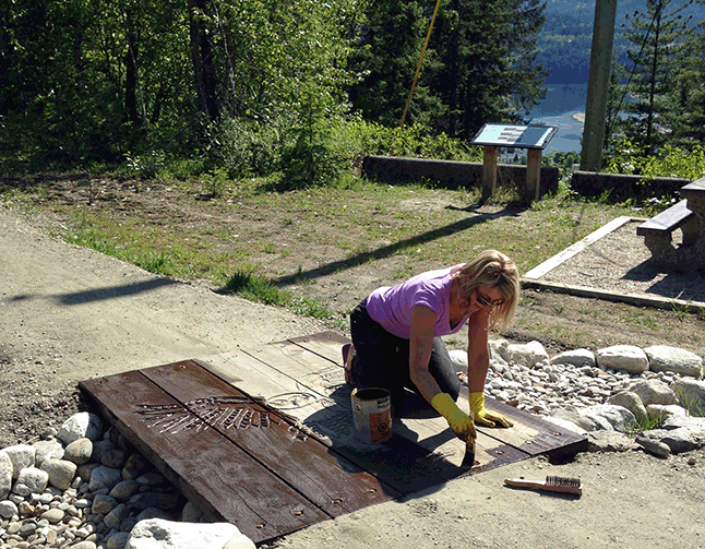 Zuzana Driediger works on the owl carving set in one of the bridges at the Bike Skills Park. Verena Blaisy photo courtesy of Parks Canada