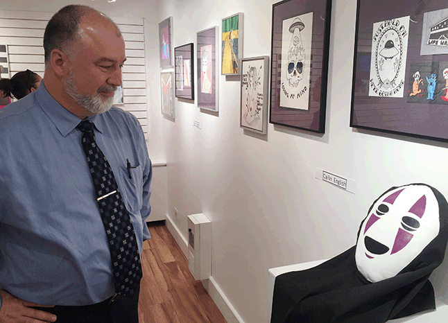 Greg Kenyon admires a mask by Cailin English. David F. Rooney photo