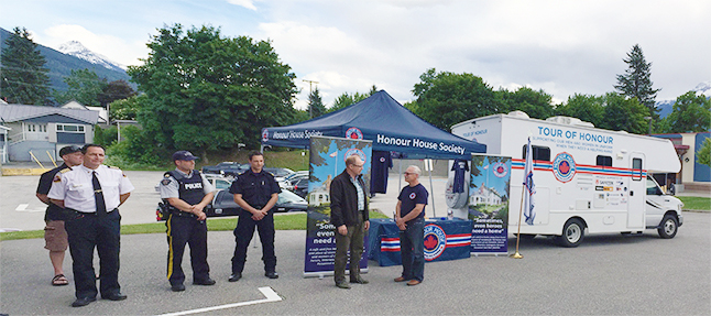 Fire Chief Rob Girard, RCMP Staff-Sgt. Kurt Grabinsky and a representative of the BC Ambulance Service standby as Councillor Gary Sulz (second from the right) talks with ??? of Honour House. David F. Rooney photo