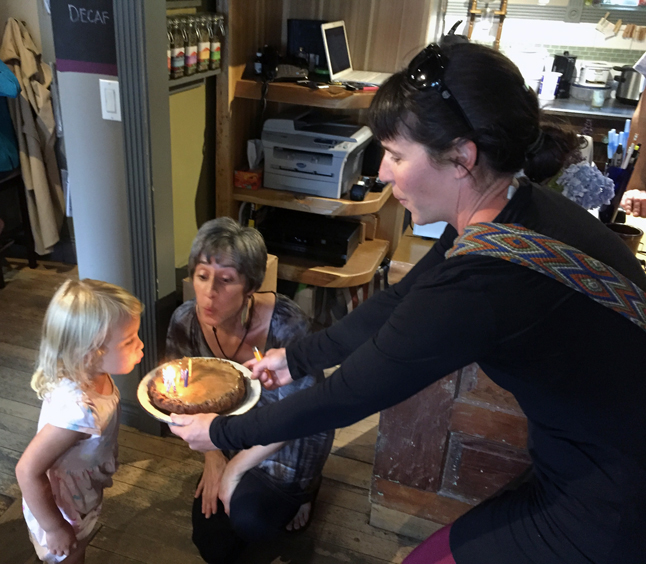 Two-and-a-half-year-old Mira Darval helps Sangha Bean proprietor Krista Cadieux blow out the candles on a scrumptious chocolate and peanut butter cake her mother Sarah brought to help the cafe celebrate its birthday on Friday, July 15. David F. Rooney photo