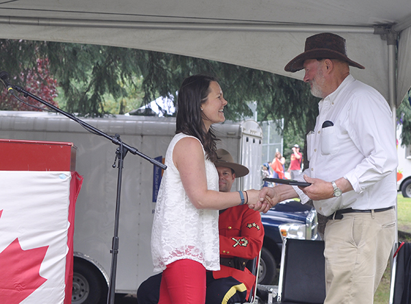 Canada Day organizer Megan MacIsaac presents George Buhler of the Rod & Gun Club with the plaque for Best Float in the parade. David F. Rooney photo