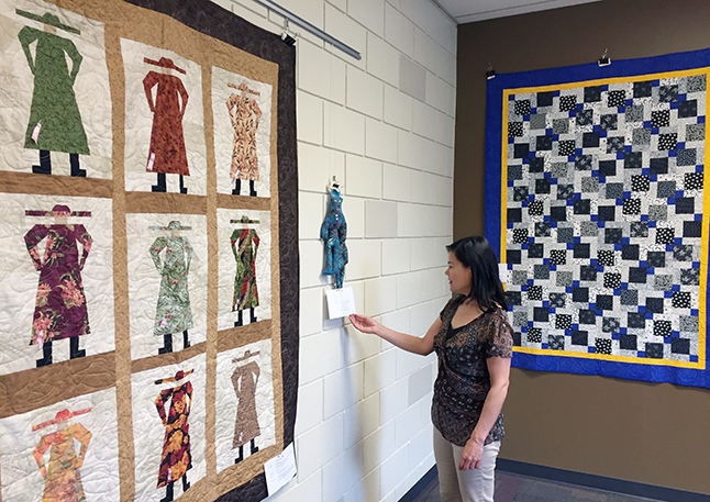 Community Librarian Kendra Runnalls admires some of the creations by Revelstoke Quilting Guild members that are now on display at the public library. David F. Rooney photo 