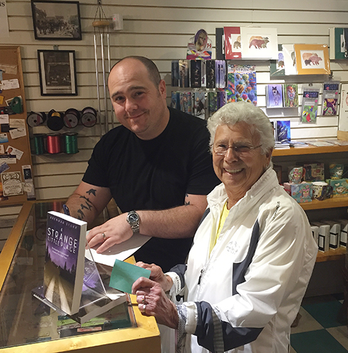 Brennan Storr signs a copy of his new book A Strange Little Place: The Hauntings & Unexplained Events of One Small Town, which describes Revelstoke's haunted history, for local resident Audrey Lally. David F. Rooney photo