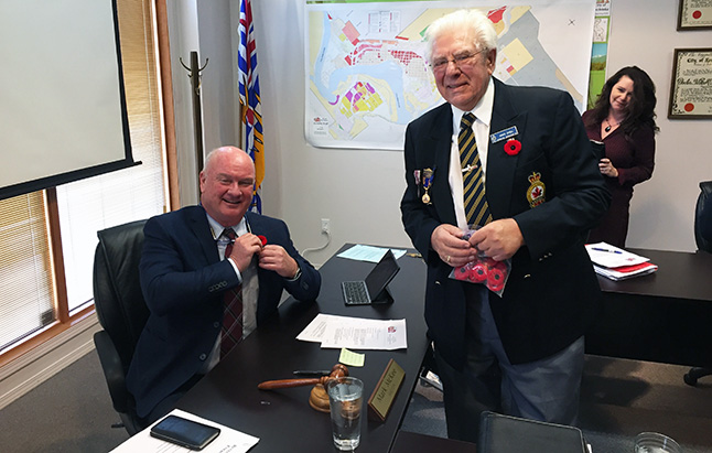 Mayor McKee grins as he adjusts the poppy on his suit jacket. David F. Rooney photo