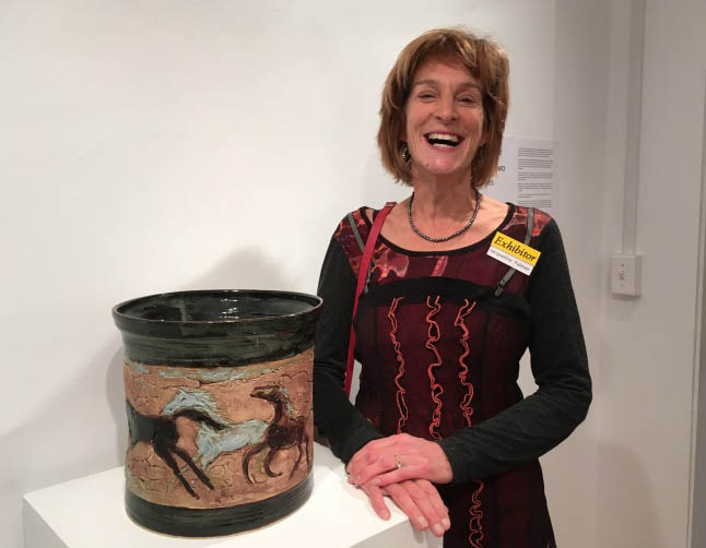 Jacqueline Palmer laughs as she poses with one the ceramics in her show, A Thousand and Two Wild Horses. Laura Stovel photo