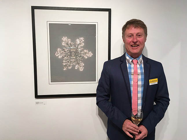 Photographer Kip Wiley poses with one of the photos in his show, Seeking the Holy Grail. Laura Stovel photo