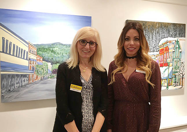 Susan and Kristi Lind pose with two of their paintings. Laura Stovel photo