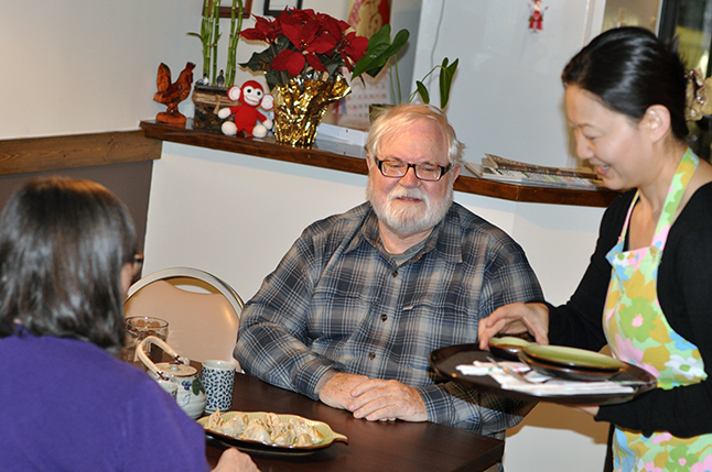Cathy and Ken English (left) started their Moonlight Madness evening by dining — like me — at Kevin's Kitchen. Here, Lu Si serves them a plate of her husband Kevin Feng's delicious home-made dumplings. David F. Rooney photo