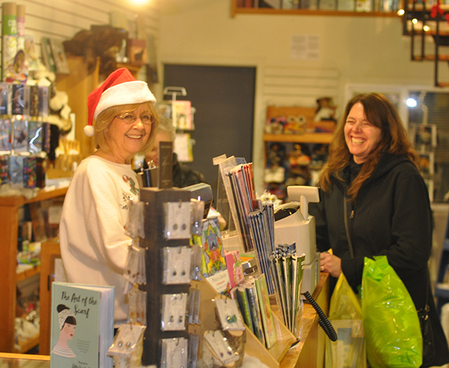 Linda Anderson and her customer share lighthearted moment at Grizzly Books. David F. Rooney photo